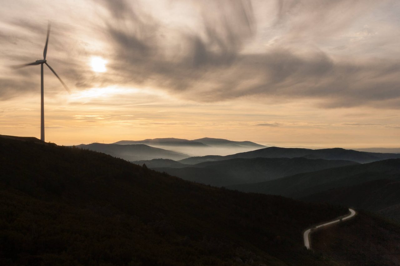 Wind turbines silhouetted on a mountain ridge at sunset